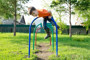 Fototapeta premium boy playing outdoors. Kid on playground, children activity. Child having fun. Active healthy childhood concept