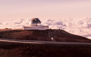Observatory domes at the peak of Mauna Kea volcano under sunset
