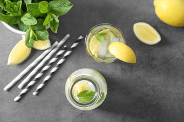 Bottle and glass of fresh lemonade on grunge background