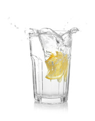 Glass of lemonade with splashing water on white background
