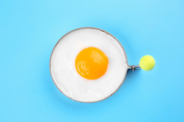 Fried sunny side up egg in round mold on color background