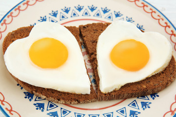 Plate with delicious sunny side up eggs and bread slices, closeup