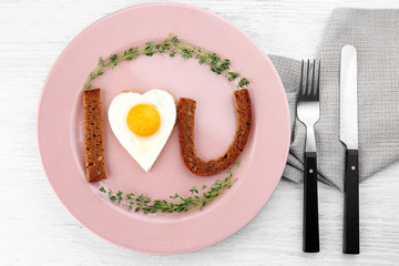 Romantic breakfast with sunny side up egg on table