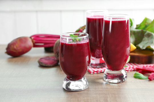 Glasses with fresh beet smoothies on wooden table