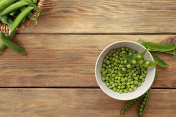 Composition with fresh green peas on wooden background