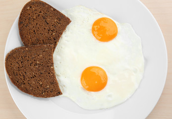 Homemade over easy fried eggs with bread on plate