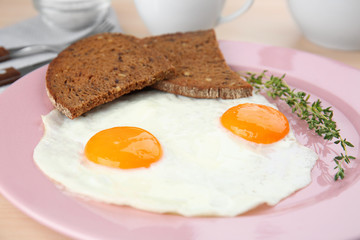 Homemade over easy fried eggs with bread on plate