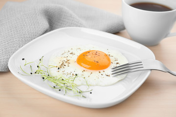 Homemade over easy fried egg with cup of tea on table
