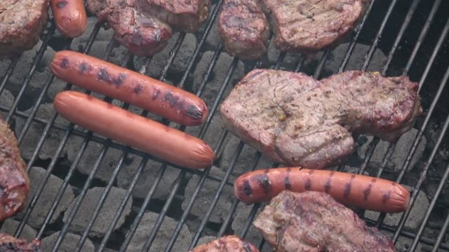Juicy steak and sausages on grill