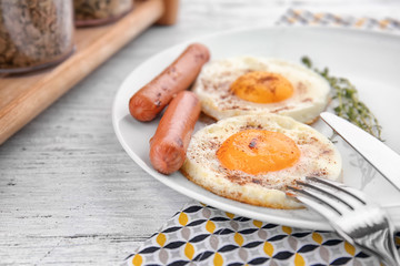 Plate of homemade over easy fried eggs with sausages on table
