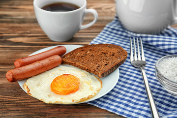 Homemade over easy fried egg with sausages and bread on plate