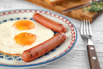 Homemade over easy fried eggs with sausages on plate