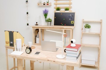 modern interior office room working space with laptop computer wooden desk and gadgets accessories with white wall