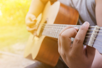 Fototapeta premium Man hands playing acoustic guitar, close up
