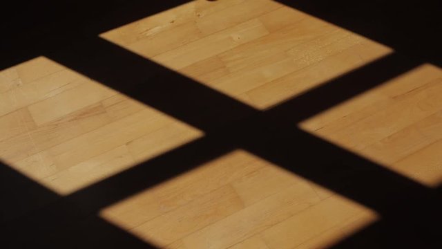 Time-lapse of shadows moving on a hardwood floor.