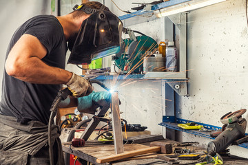 man welds a metal welding machine
