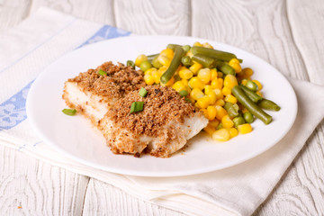 Baked codfish in breadcrumbs and vegetables
