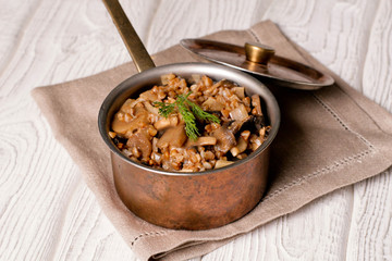 Buckwheat porridge with mushrooms in the copper pan