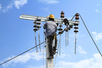Obraz premium Electrician working on electric power pole