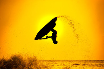 man drive freestyle jet ski at sunset.