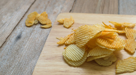 potato chips on wooden block