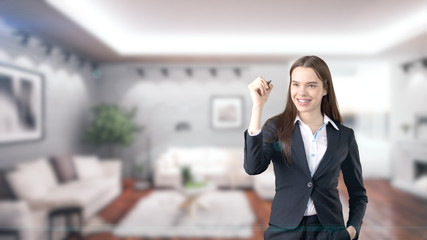 Fototapeta premium Young beautiful business woman and creative designer standing over blured interior background