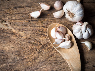 Garlic cloves and bulbs on wooden table in top view.