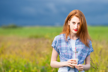 Redhead skinny girl holding milkshake 