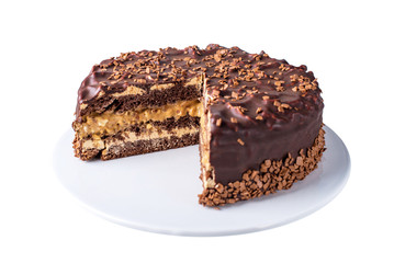 isolated chocolate layered cake with nougat and sponge cake in the cut on the plate