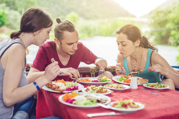 Young people are eating vegetables and fish outdoors in a cozy restaurant on the water, opens new kitchen