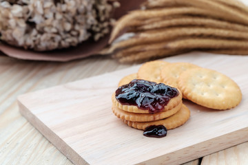 Cracker with jam on woodden background