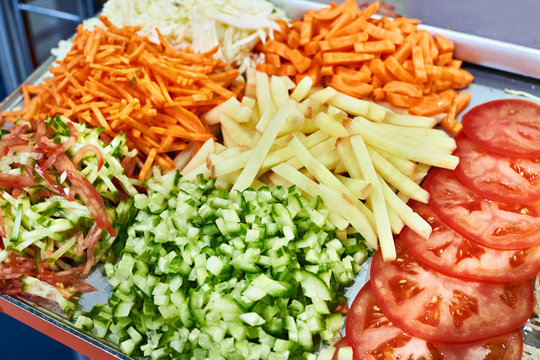 Sliced vegetables for salad in kitchen