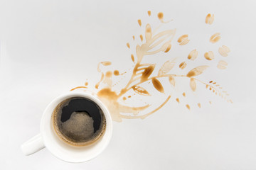 top view of cup of coffee and brown stains in floral shape on grey