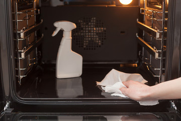 Housework and housekeeping concept. Cleaning the stove and oven. Close up of female hand with dry...
