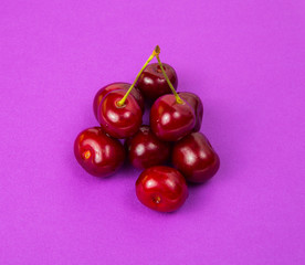  Large red cherry on a background of lilac paper