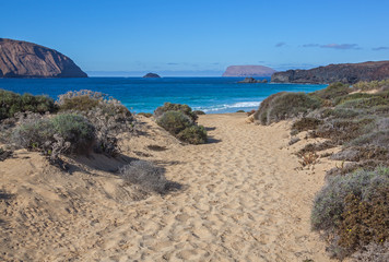 Fototapeta na wymiar Footpath to the beach with golden sand on Graciosa island near Lanzarote, Canary Islands, Spain