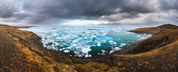 Beautiful 180 degree panoramic view of the floating blue ice in the Jokulsarlon lake in Iceland in...