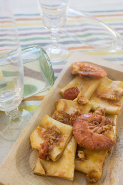 paccheri at the sauce of prawns in a wooden dish
