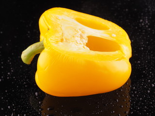 Yellow pepper on a dark background with droplets
