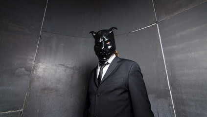 A corporate man in a dirty scruffy suit wearing a black pigs mask in a dark sinister background,...