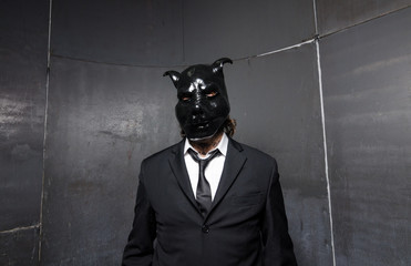 A corporate man in a dirty scruffy suit wearing a black pigs mask in a dark sinister background,...
