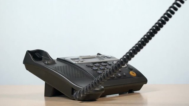 The man is calling on the phone. A close-up of a telephone set.