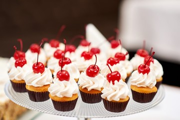 Plate with delicious cupcakes with cream and cherries on top food delicious eating sweetness butter cream.