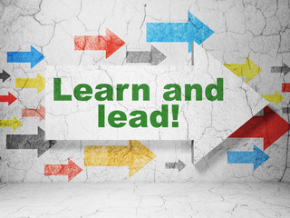 Learning concept: arrow with Learn and Lead! on grunge wall background
