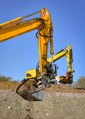 Baubranche - Erdarbeiten - mit Erdreich bef&uuml;llte Baggerschaufel 
