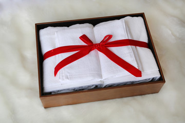 White towel gift in leather box on artificial fur background.
