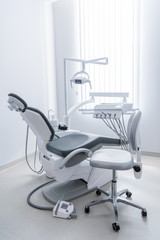 empty dentist office with chair and various dental equipment