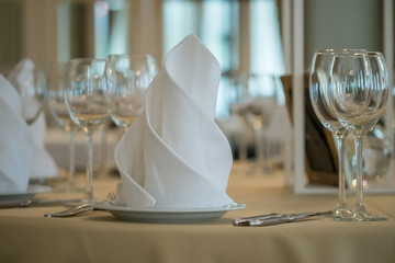 Empty glasses set with napkins in restaurant