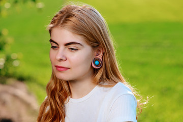 Portrait of a young beautiful woman with wooden tunnels in her ears