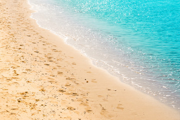 Seashore with footprints on the sand, light blue sea, italian beach in Salento, natural marine background
